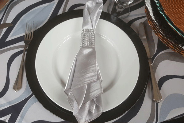 catering plates and silverware wrapped in a silver napkin